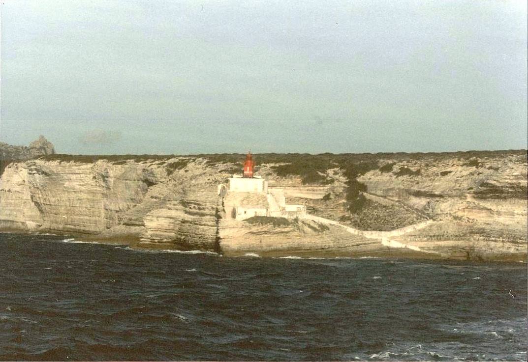 Faro rosso sulla scogliera calcarea di Bonifacio vista dal mare
