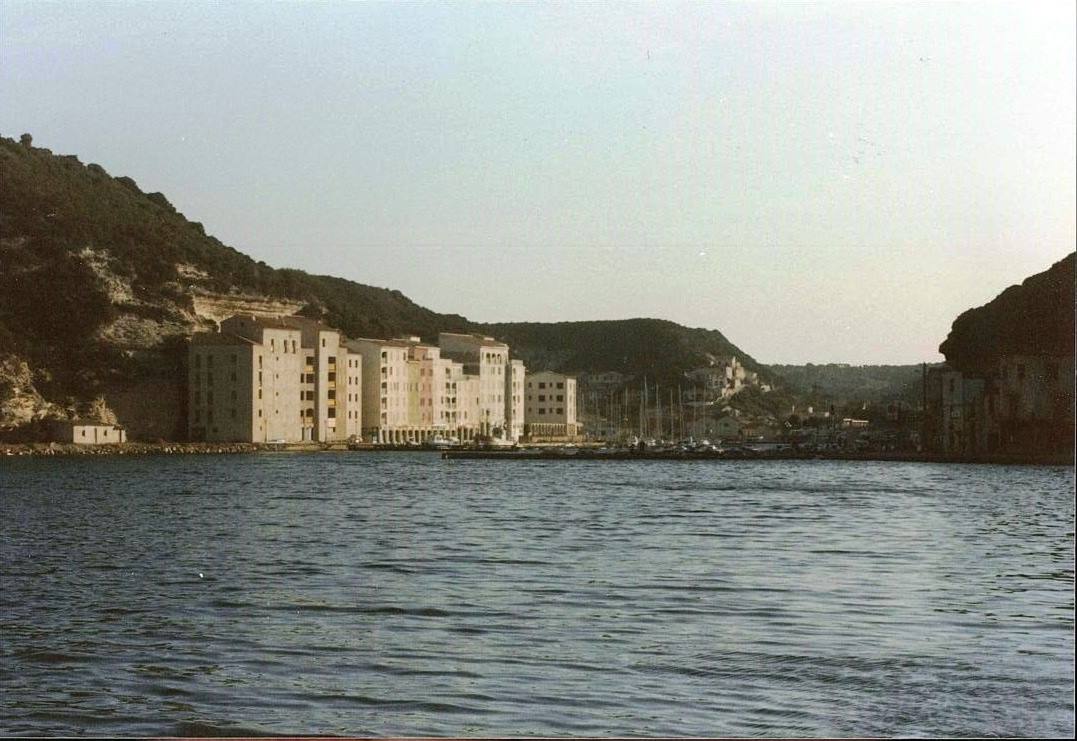 Porto di Bonifacio: case chiare sulla riva, barche ormeggiate, scogliere alle spalle