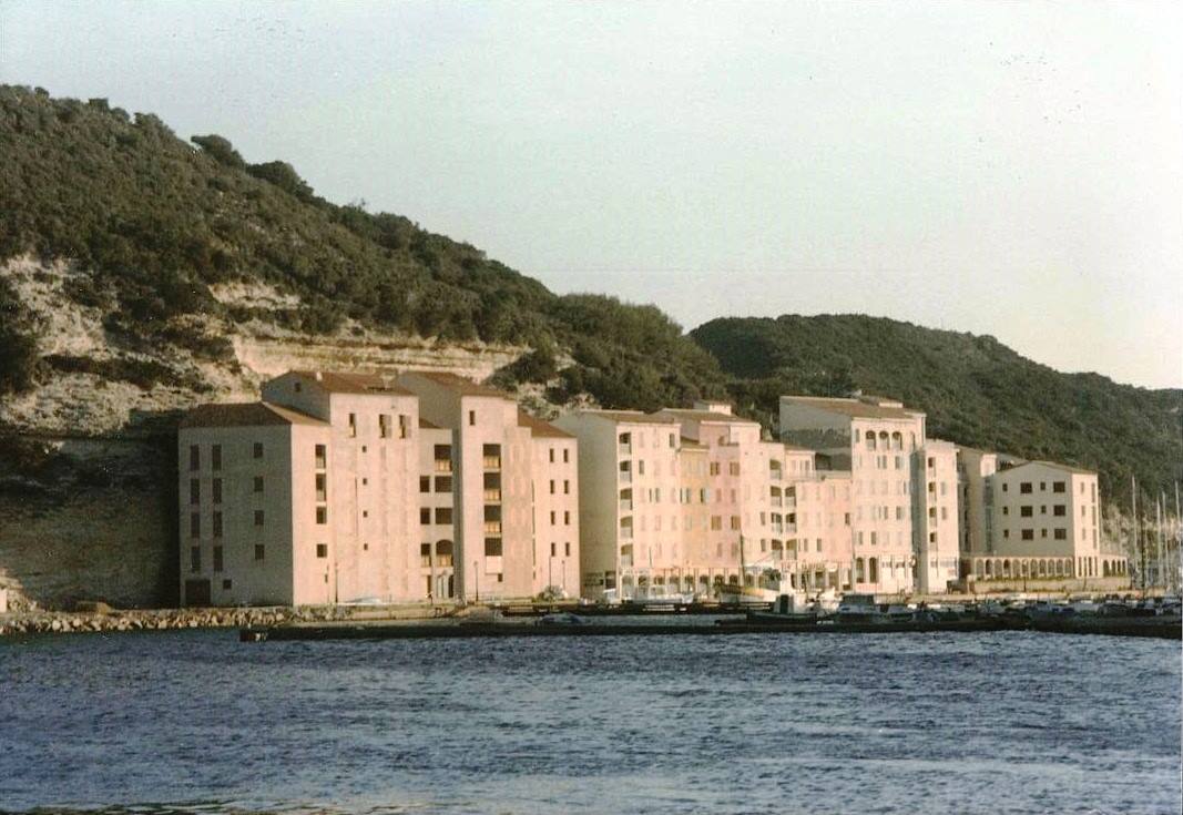 Palazzi color crema sul lungomare sotto la scogliera calcarea di Bonifacio