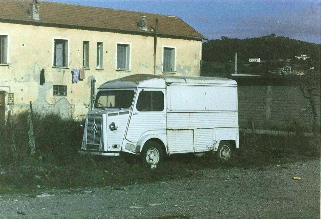Furgone Citroën bianco ormai arrugginito accanto a una casa gialla