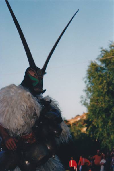 Mamuthones mask from Mamoiada wearing white fur, bells and long horns