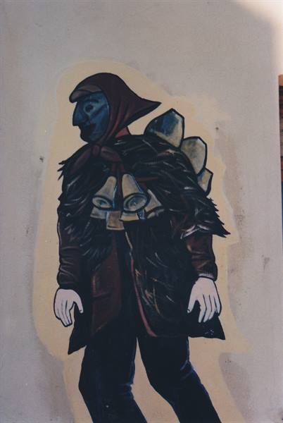 Mural of a mamuthone figure with black mask, bells and fur cloak