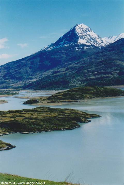 Snow-capped peak over a turquoise lake with grassy islets, Torres del Paine