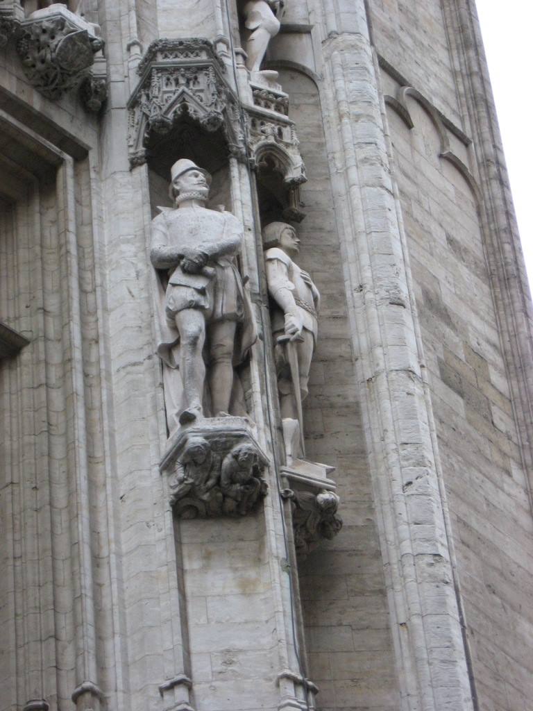 Statue di pietra di cavalieri in nicchie gotiche sul municipio di Bruxelles