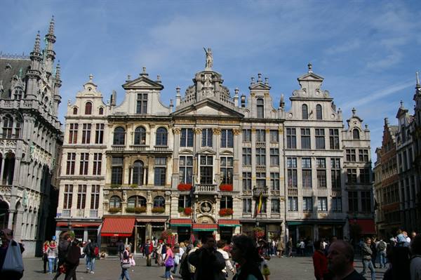 Tourists stroll before the ornate baroque guildhalls of Brussels' Grand-Place