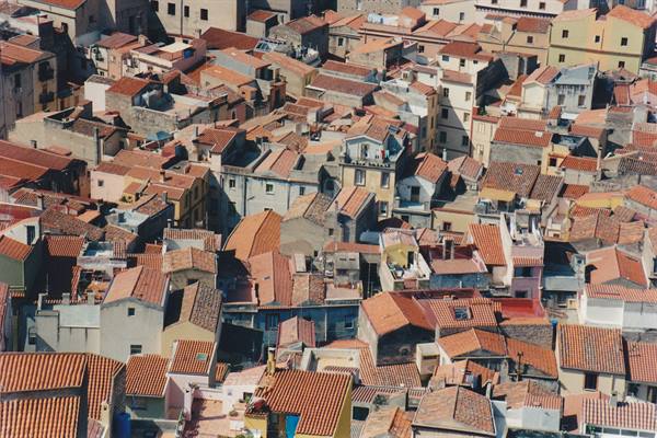 Terracotta rooftops crowding the old town of Bosa under sunlight