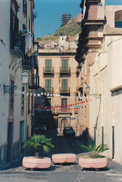 Alley with palm planters, colored festival flags and old buildings