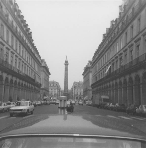 Vendôme Column seen from a car between stone buildings