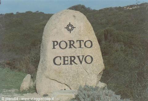 Granite boulder engraved Porto Cervo with compass rose, amid Mediterranean scrub