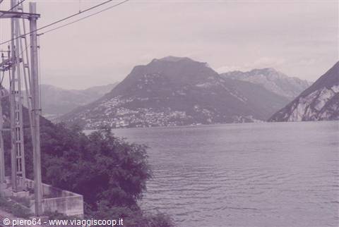 Lake Lugano with Monte Brè, electric cables and trees in foreground, vintage photo