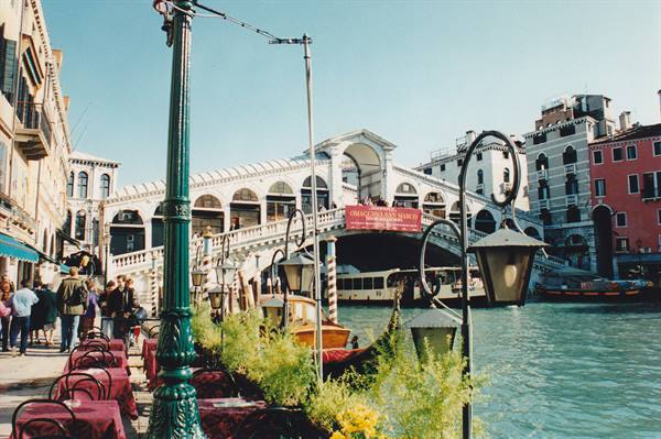Tourists on the waterfront in front of Rialto Bridge in Venice