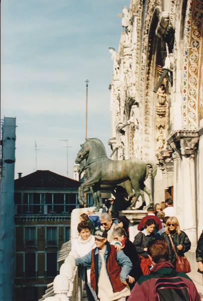 Tourists on St Mark's Basilica terrace beside the bronze horses