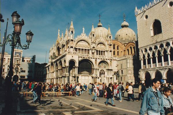Tourists and pigeons in St Mark's Square by the basilica, Venice