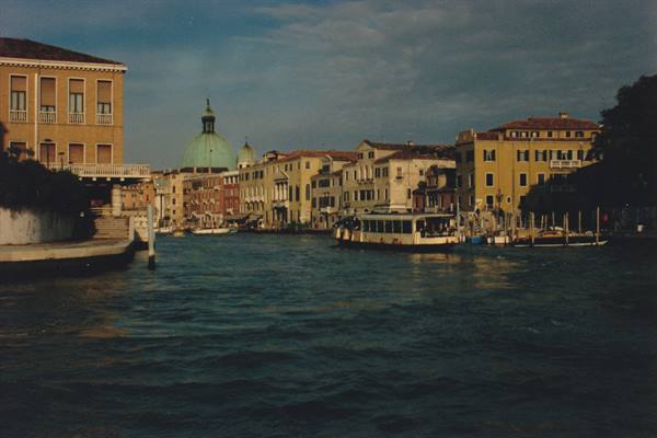 Vaporetto on Venice's Grand Canal, dome and palaces under cloudy sky