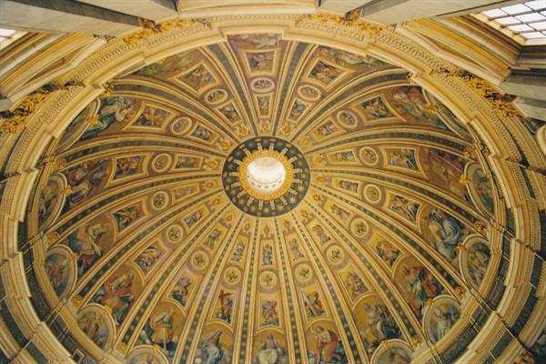 Golden dome with mosaic segments and glowing lantern, St. Peter's Basilica