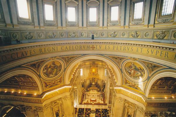 St. Peter's dome interior: golden Latin inscription, mosaics, Bernini's baldachin below