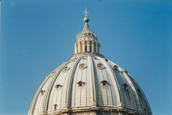 St. Peter's Basilica dome in Vatican, white travertine under blue sky
