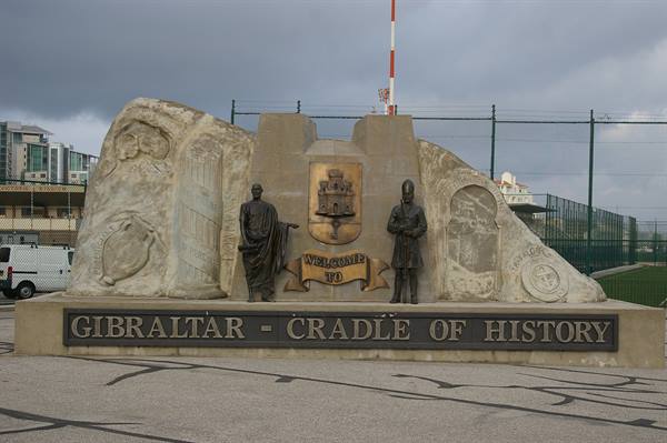 Stone monument with bronze statues and Welcome sign, in Gibraltar