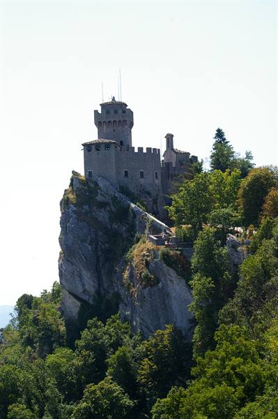 Guaita, medieval stone tower on rocky cliff above the woods, San Marino