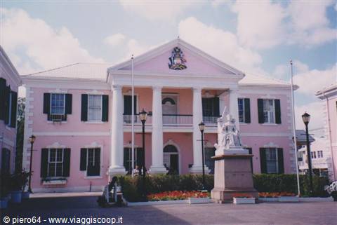 Pink Parliament building with white columns and statue in Nassau