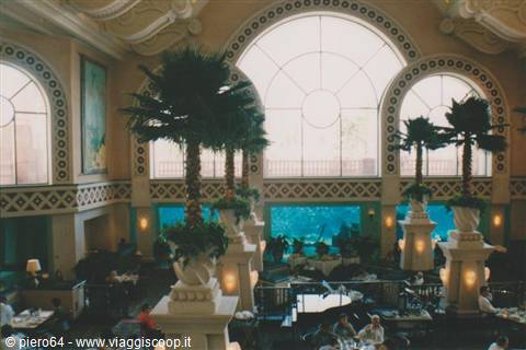Lobby with palm trees and large arches, light through wide windows