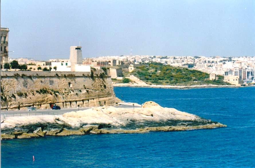 Mura calcaree e torre di guardia sul porto di Malta, mare azzurro