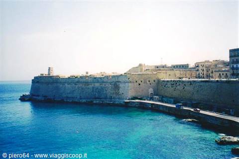 Limestone bastion walls above turquoise sea, fortified old town by the harbour