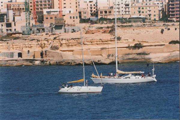 Two yachts moored off Sliema, rocky shore and buildings behind