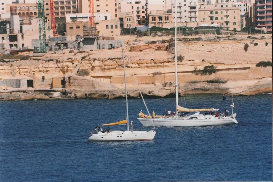 Due velieri in bacino a Sliema, costa rocciosa e palazzi in cantiere