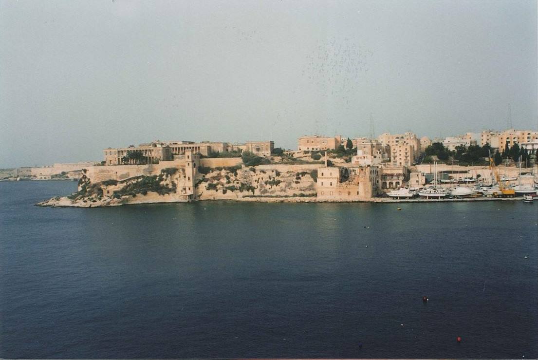Mura calcaree e edifici ocra sulla penisola di Valletta, porto con barche