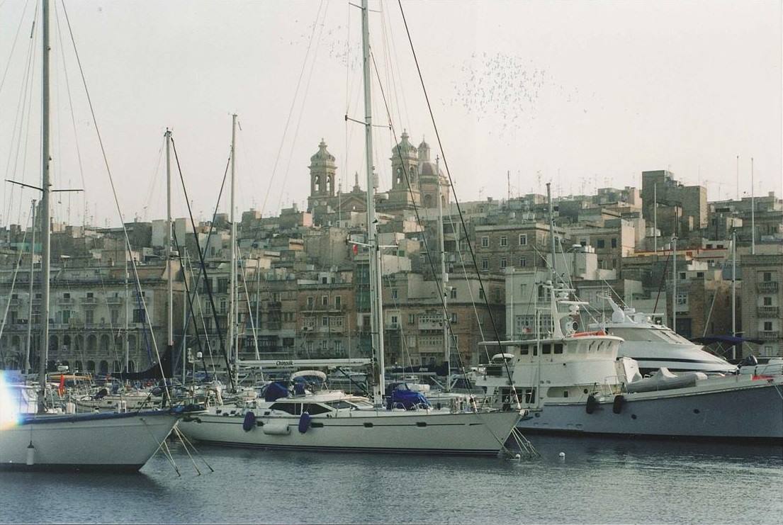 Barche a vela ormeggiate al porto davanti alle cupole e ai tetti della città
