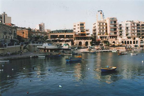 Colorful boats in Spinola Bay, St Julian's, buildings along the waterfront
