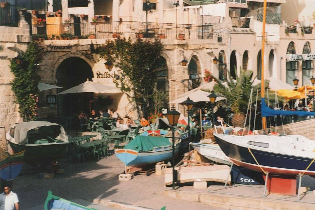 Barche in secco al porto di Giaffa, caffè con ombrelloni tra gli archi in pietra