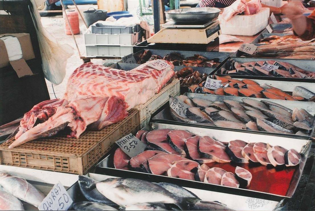 Banco del mercato del pesce con fette di tonno fresco e bilancia
