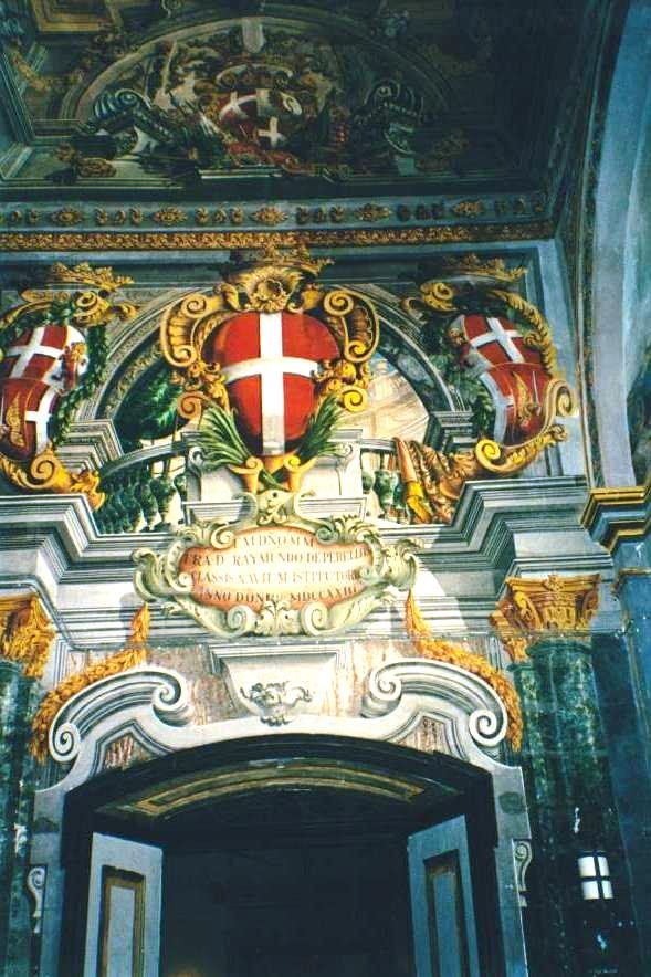 Stucchi dorati e stemmi con croce rossa sopra il portale di una chiesa barocca