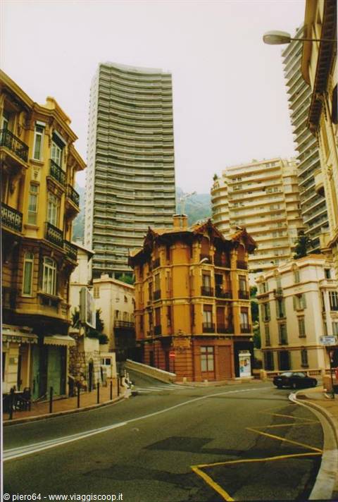 Ochre Art Nouveau building among modern towers, empty streets of Monte Carlo