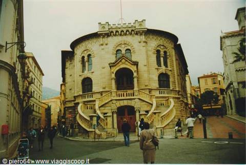 Light stone building with double spiral staircases, people walking on the street