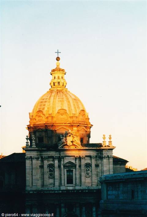 Baroque dome in Rome glowing golden at dusk, topped by iron cross