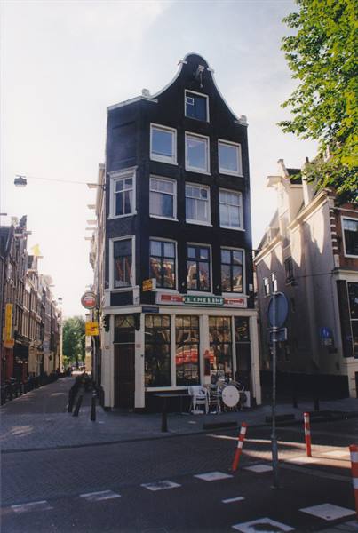 Black gabled corner house on an Amsterdam canal, morning light