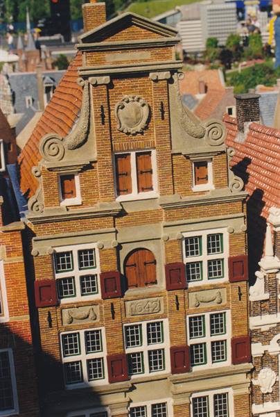 Brick facade with baroque gable, tiled roofs, morning light