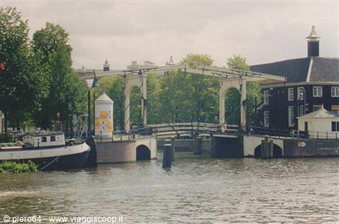 Wooden drawbridge over Amsterdam canal, houseboat moored in foreground