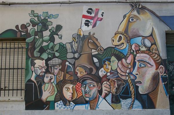 Mural with faces, horse and Sardinian flag painted on city wall