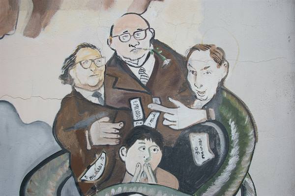 Satirical mural of suited men clutching banknotes, quarreling, painted on a wall