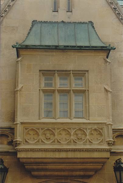 Carved stone balcony with floral motifs and oxidized copper roof