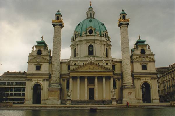 Karlskirche in Vienna, green dome and Baroque columns under grey sky