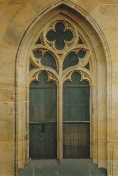 Gothic sandstone window with quatrefoil tracery in Prague