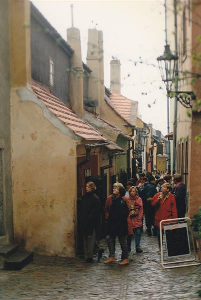 Tourists in Golden Lane, small colored houses with red roofs, grey light