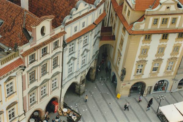 Burgher houses with red tiled roofs over a paved Prague square