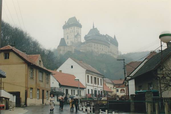 Karlštejn Castle in the fog above the village houses
