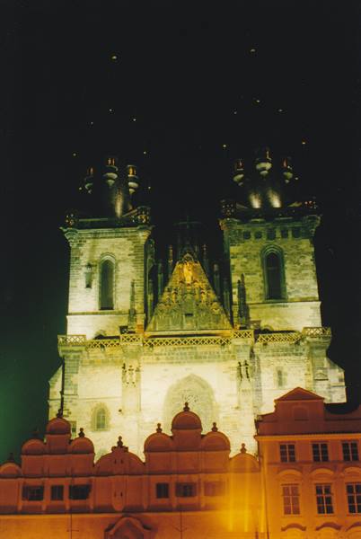 Tyn Church illuminated at night in Prague, Gothic spires against dark sky